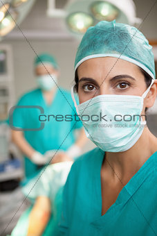 Serious surgeon standing in front of a colleague