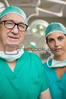 Surgeon with glasses on and a colleague