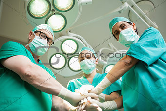 Surgical team joining hands