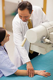 Smiling doctor placing the arm of a patient on a table