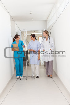 Doctor walking with a patient and a nurse