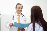 Doctor holding a document while talking to a patient