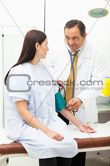 Doctor measuring the pressure of the blood of his patient