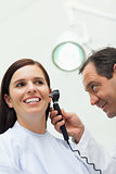 Doctor using an otoscope to look at the ear of a patient