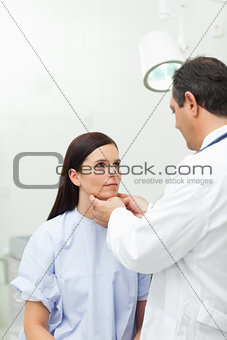 Doctor touching the neck of a patient