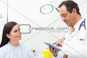 Doctor talking with a patient while using a tablet
