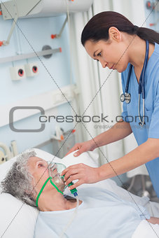 Nurse putting oxygen mask on a patient