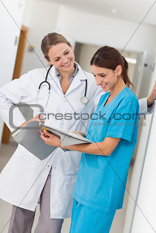 Smiling nurse and a doctor looking in a file