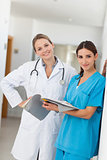 Nurse and a doctor holding a file in a hallway
