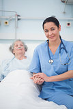 Nurse sitting on the bed next to a patient