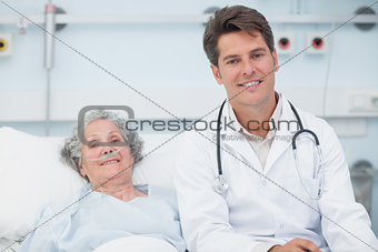 Doctor sitting on the bed next to a patient