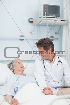 Doctor looking at a patient while taking her hand