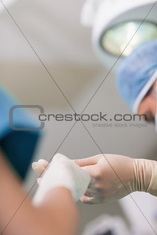 Close up of a nurse giving a surgical scissor to a doctor