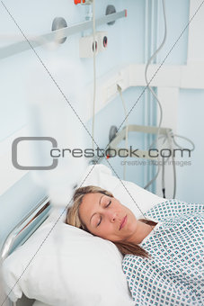 Woman lying on a medical bed while closing her eyes