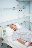 Female patient lying on a medical bed with closed eyes