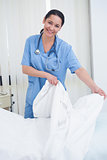 Nurse changing sheets on the bed