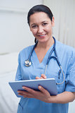Nurse looking at camera while holding an ebook