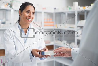 Smiling pharmacist giving a box to a doctor