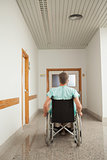 Male patient sitting in a wheelchair in the corridor