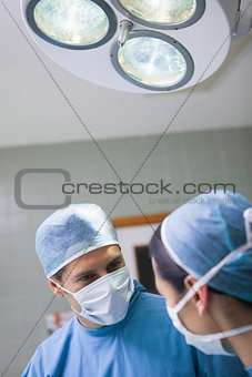 Doctor looking at a nurse below the light