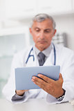 Doctor holding a tablet computer while using it