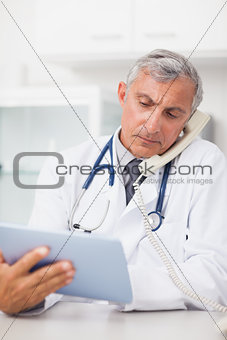 Doctor using a tablet computer while calling