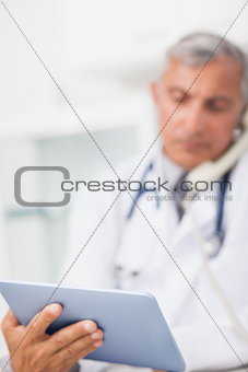 Focus on a doctor holding a tablet computer