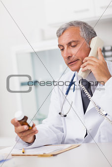 Doctor holding a phone and drug box