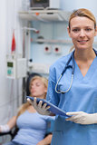 Nurse holding a clipboard next to a patient