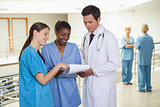 Doctor holding a clipboard next to nurses