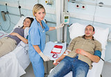Nurse touching monitor next to transfused patients