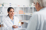 Female pharmacist holding a drug box