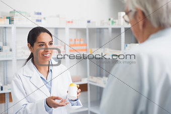 Female pharmacist holding a drug box