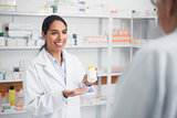Smiling pharmacist holding a drug box