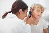 Doctor auscultating the ear of a child