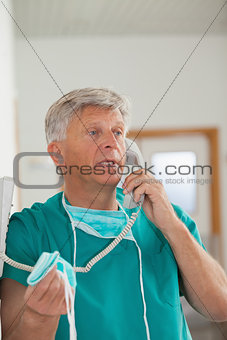 Surgeon talking while holding a phone