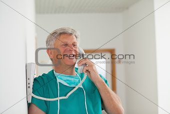 Surgeon smiling while holding a phone