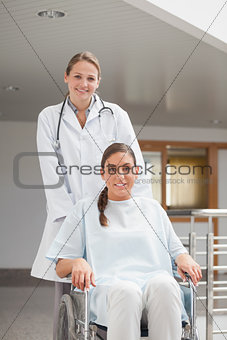 Smiling doctor next to a patient on a wheelchair