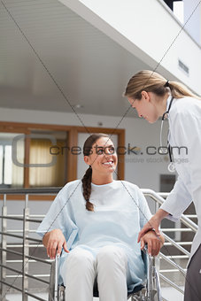 Smiling doctor touching a patient on a wheelchair