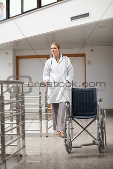 Thoughtful doctor standing next to a wheelchair
