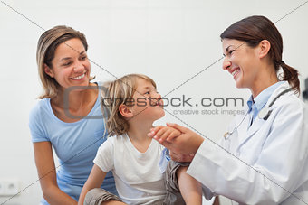 Smiling doctor auscultating the forearm of a child