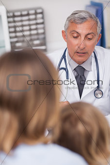 Patients and doctor sitting at a desk