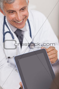 Doctor holding a tablet computer while smiling