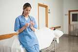 Nurse leaning on a medical bed