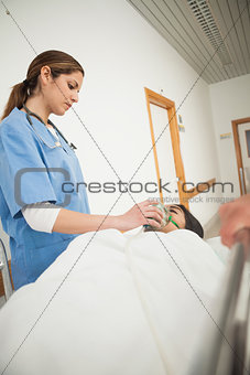 Nurse putting oxygen mask on a female patient