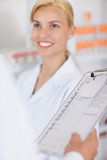 Blonde pharmacist smiling to someone