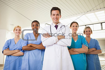 Smiling doctor and nurses with arms crossed