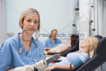 Nurse holding a clipboard next to a transfused patient