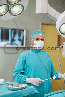 Surgeon holding a surgical tool