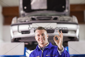Smiling mechanic doing a gesture with his fingers